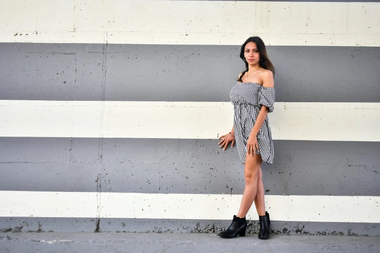 a woman posing for a pograph in front of an orange brick wall