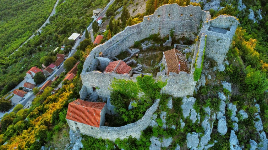 an aerial view of an old stone castle with red roof