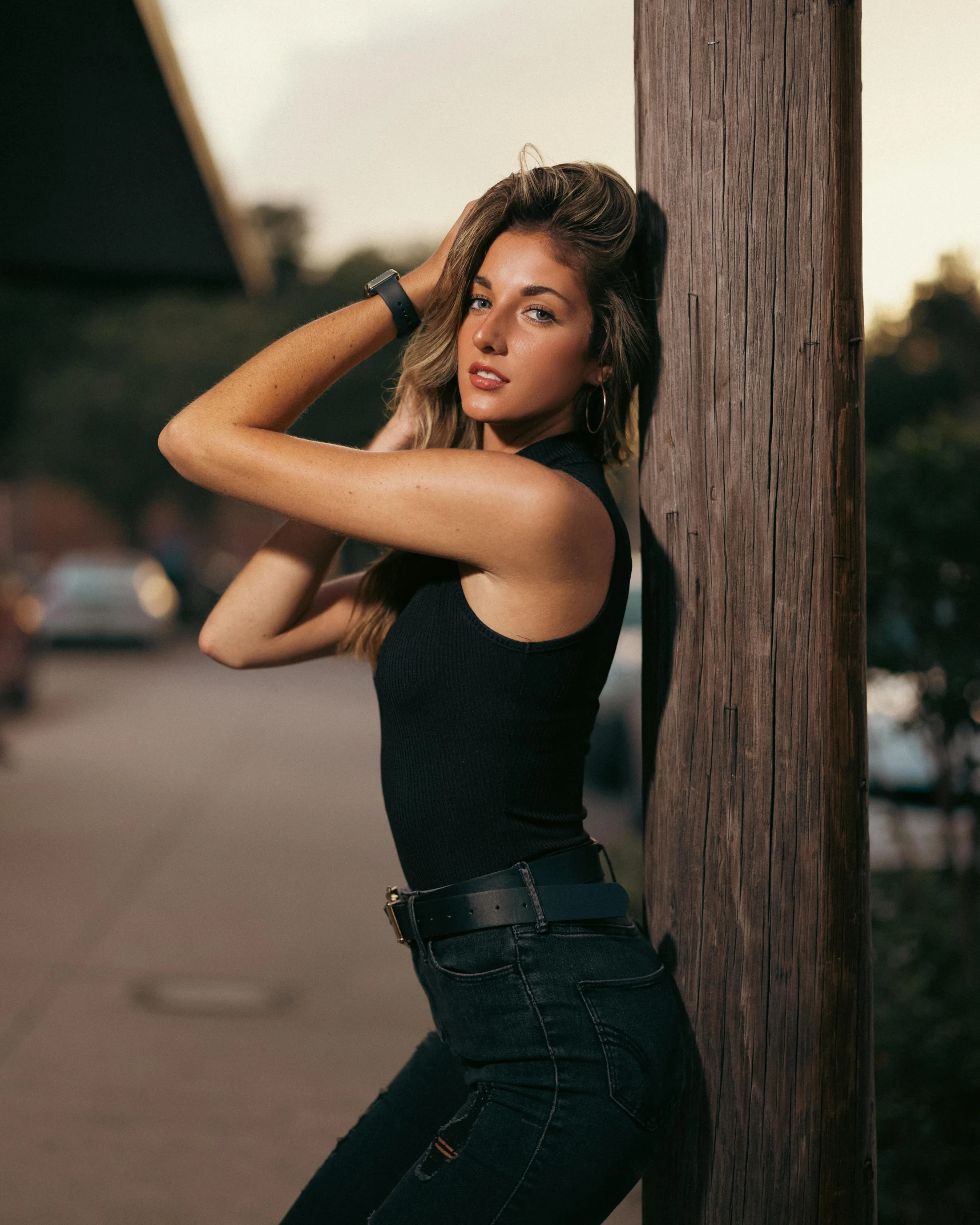 a young woman leaning against a telephone pole