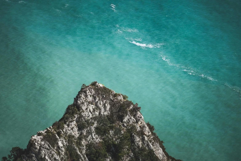 the rock and sea are seen from above