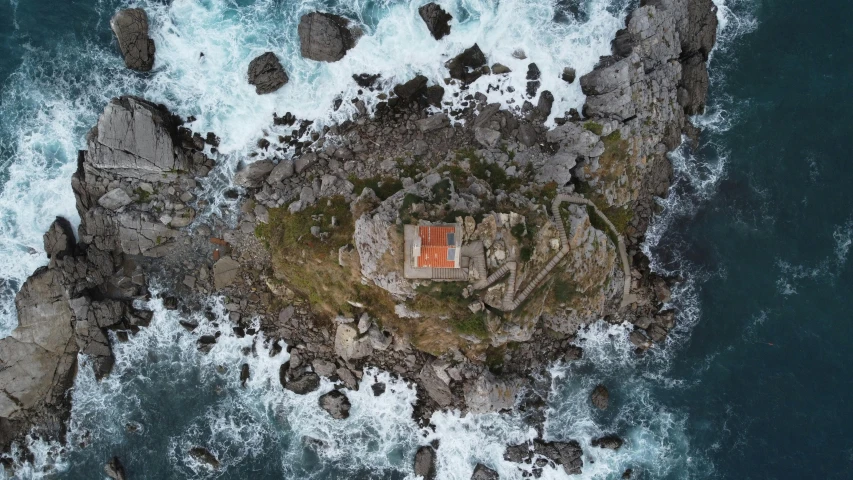 an aerial view of a house on the rocks