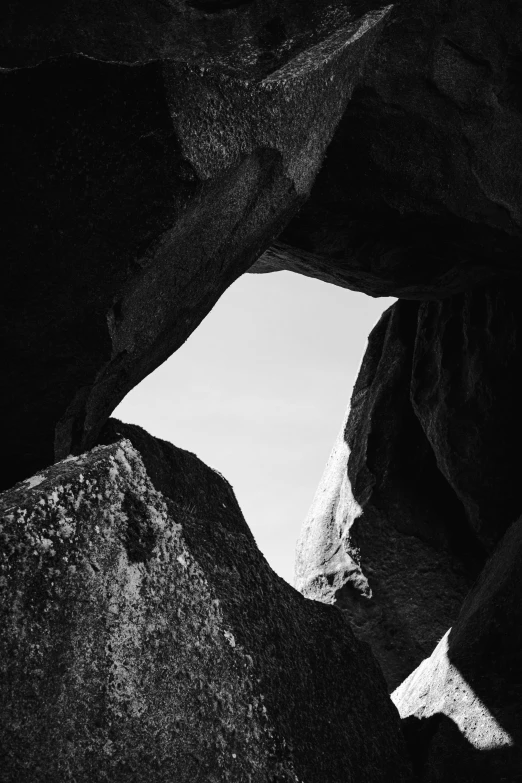 a dark cave with some large rocks and a white mountain