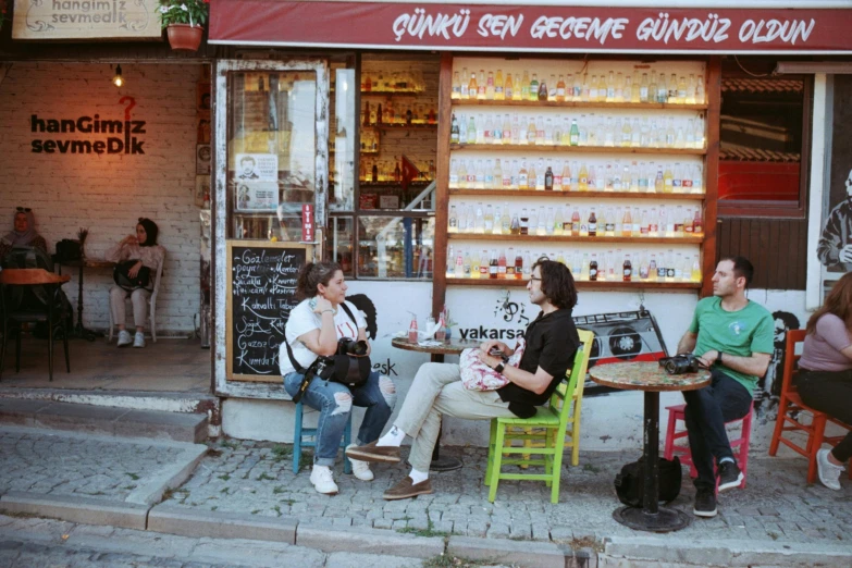 three girls sitting on different chairs outside a store