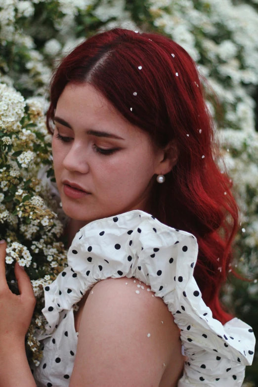 there is a young lady that is smelling flowers