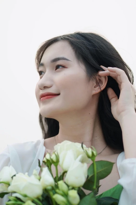 a woman holding onto flowers, with an upclose and white background