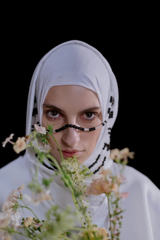 the young woman is holding flowers in her hand