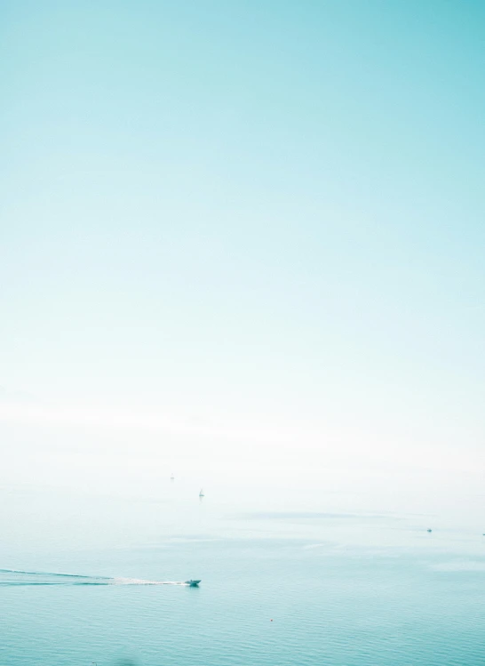 a sailboat on the ocean and people sitting on the shore