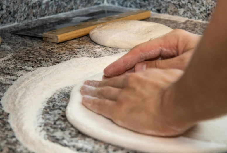 someone rolling dough on a surface with a rag