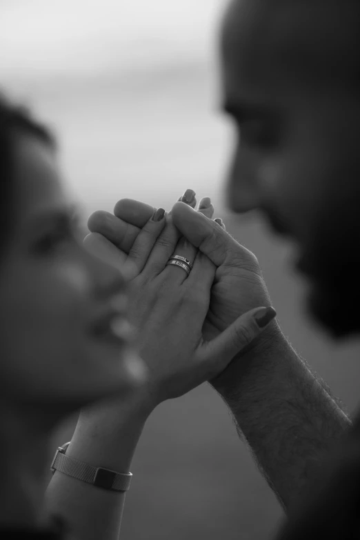 black and white po of a couple holding hands and touching each other