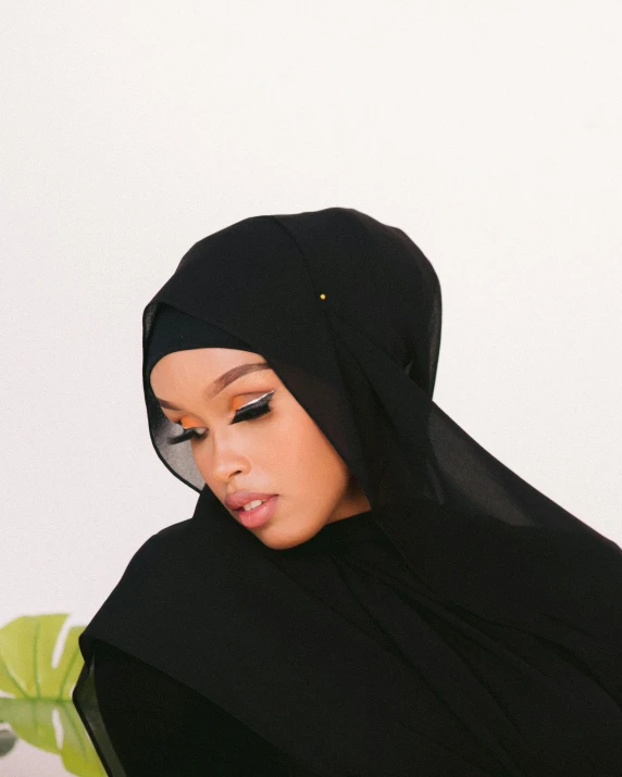 an indian woman in black veil, leaning on the wall