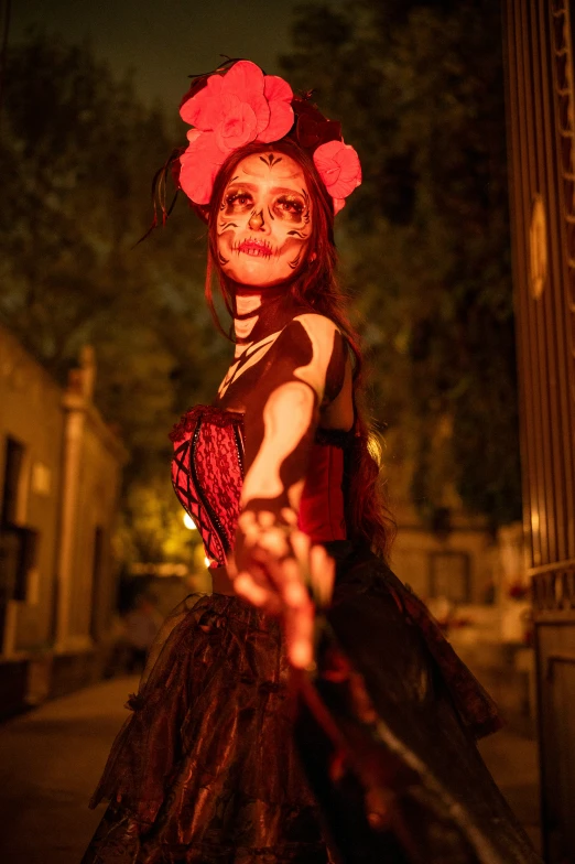 a woman dressed in black and red is walking along the street