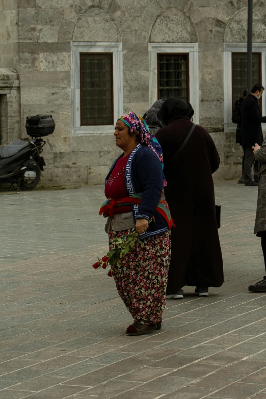 a woman in colorful dress walking down a street