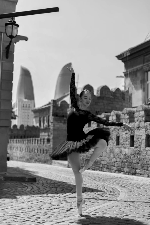 a girl is doing a ballet pose while in black and white
