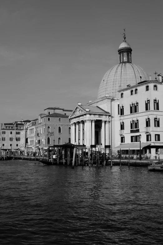 a black and white po of an old building next to the water