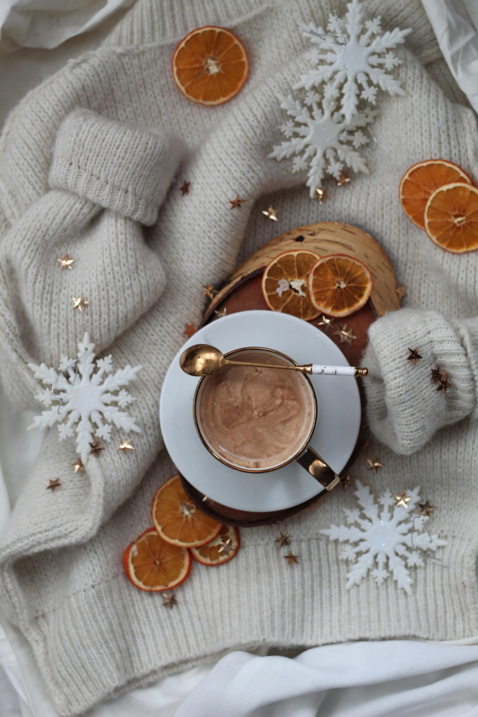 coffee and oranges are set on a blanket