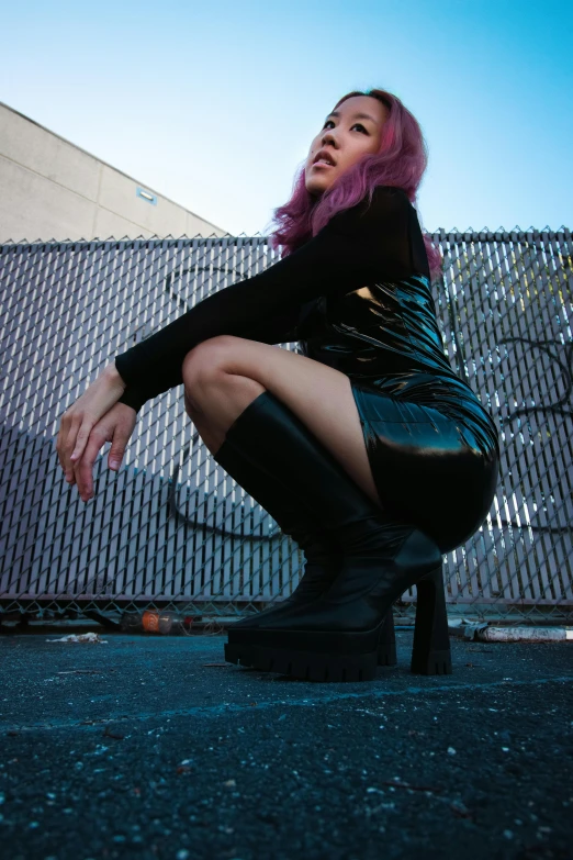 a woman in black boots and tight pants posing