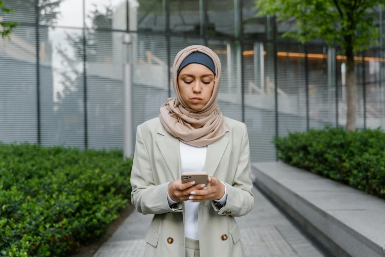 a young woman in a scarf checking her cell phone