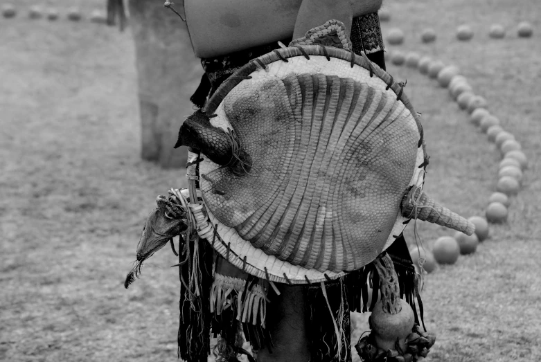 a woman in native dress is carrying a instrument