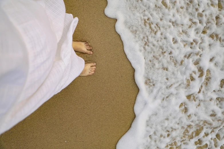 a person is lying on the beach with their feet up