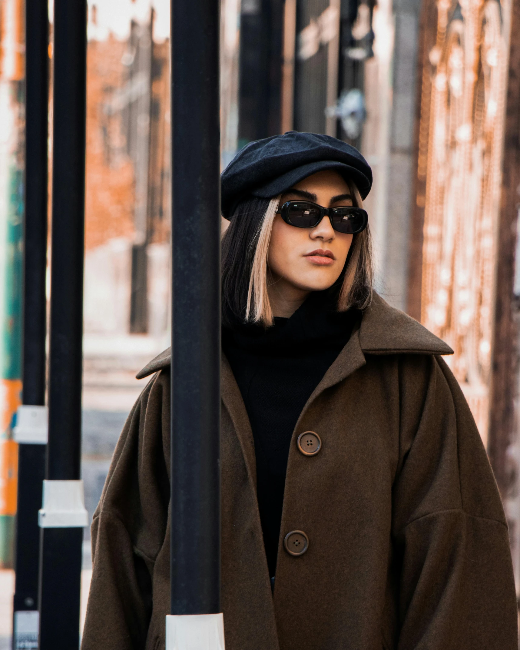 a woman wearing a brown coat and a black hat