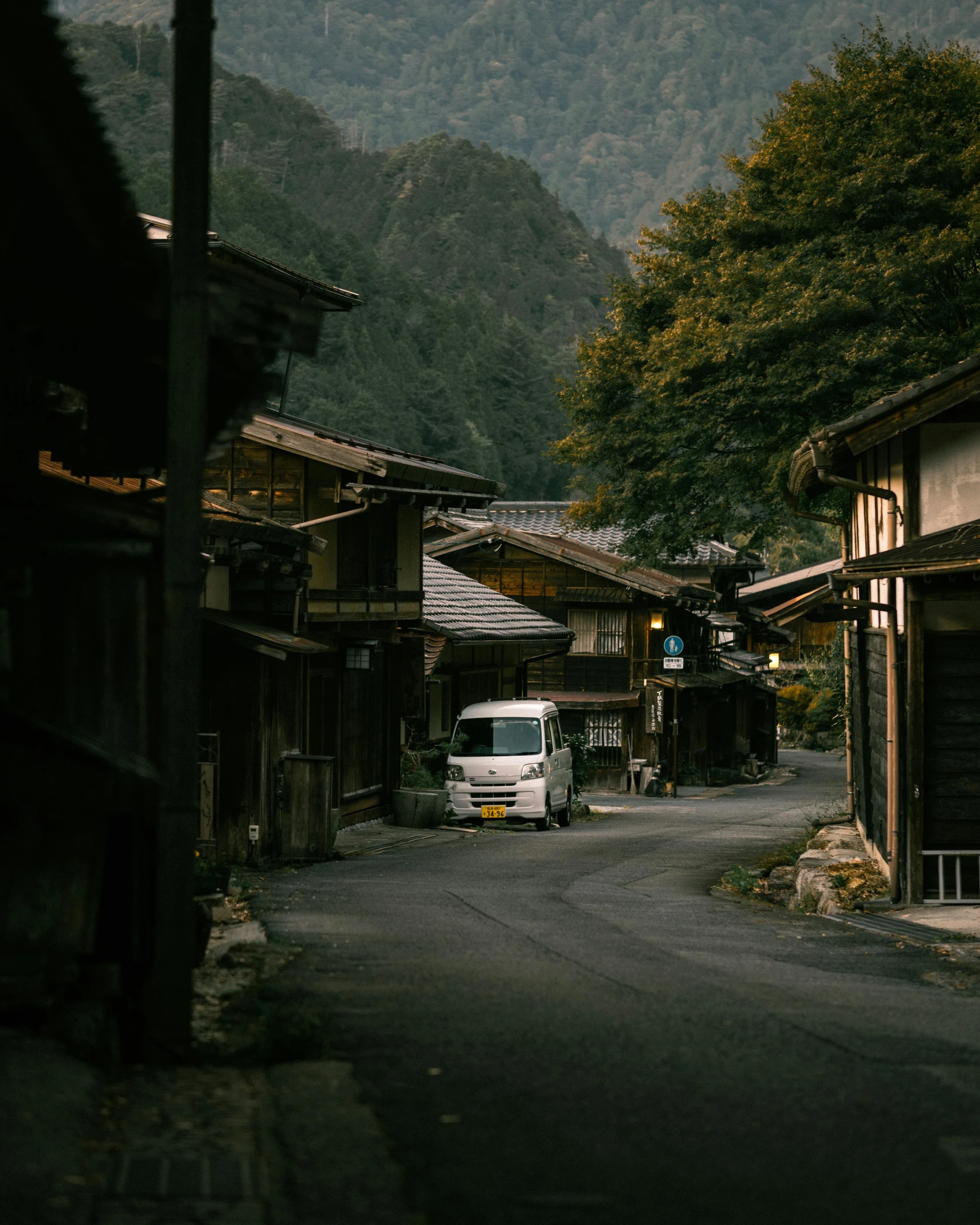 an old van on a narrow street in the mountains