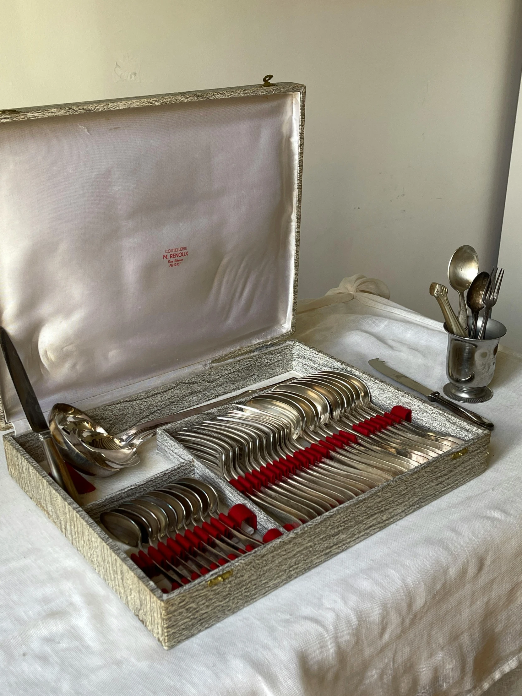 a tray with silver spoons and forks, silverware on a table