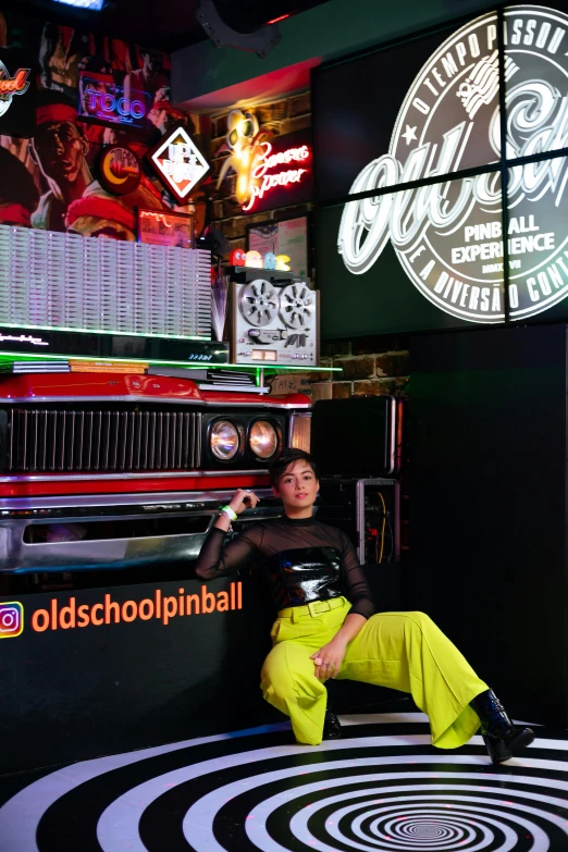 an asian man sitting in front of a radio station advertit