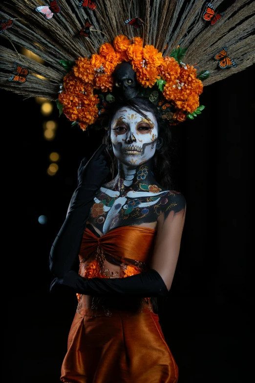 a woman with white makeup wearing orange flowers and a costume