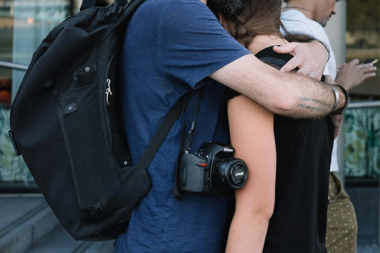 a man with a camera in his hands and a woman holding the other man