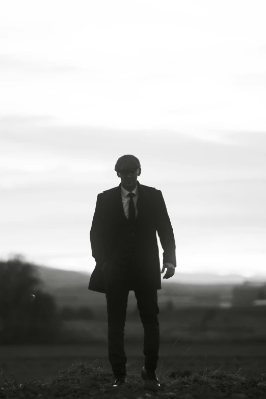 the man in a suit and tie is standing in the grass