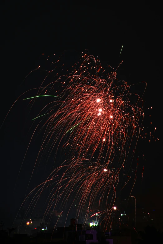 large red fireworks with colorful streamers in the sky