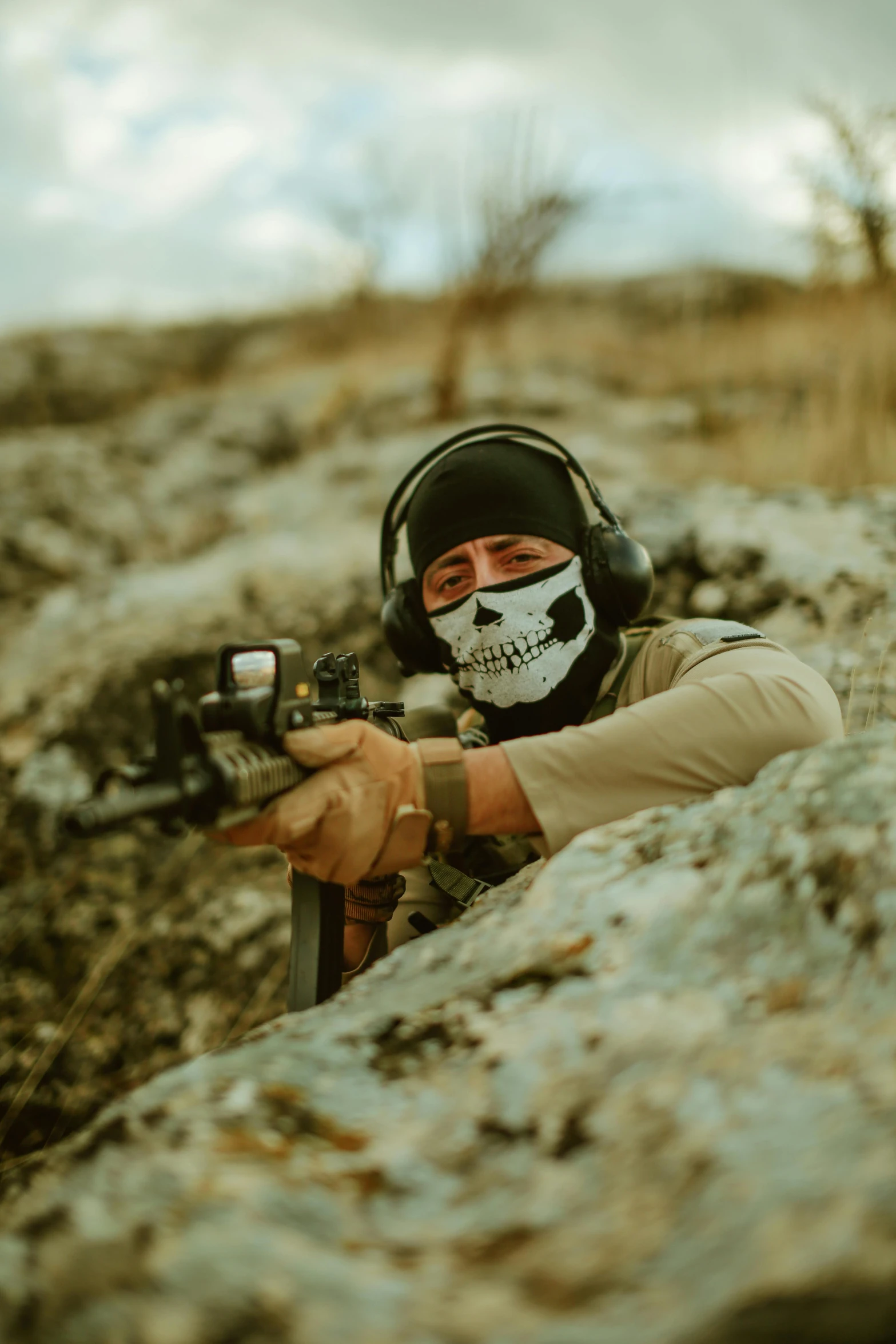 a man with a skull face paint holding a machine gun