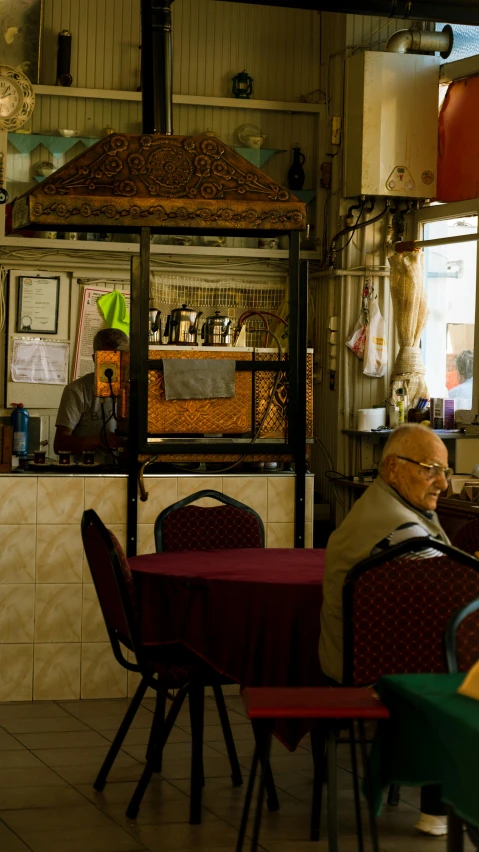 two men sitting at tables and looking at their cellphones