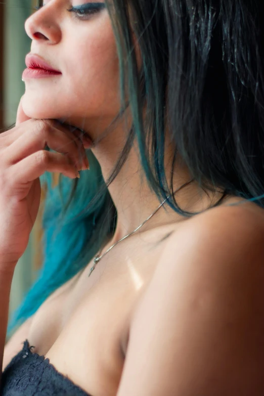 a close up image of a woman with dark hair and blue makeup