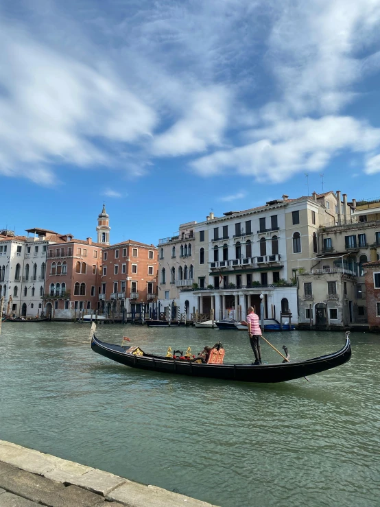 a gondola on the canal is on a cloudy day