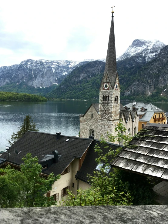 a church in the mountains on a steeple overlooking some lake