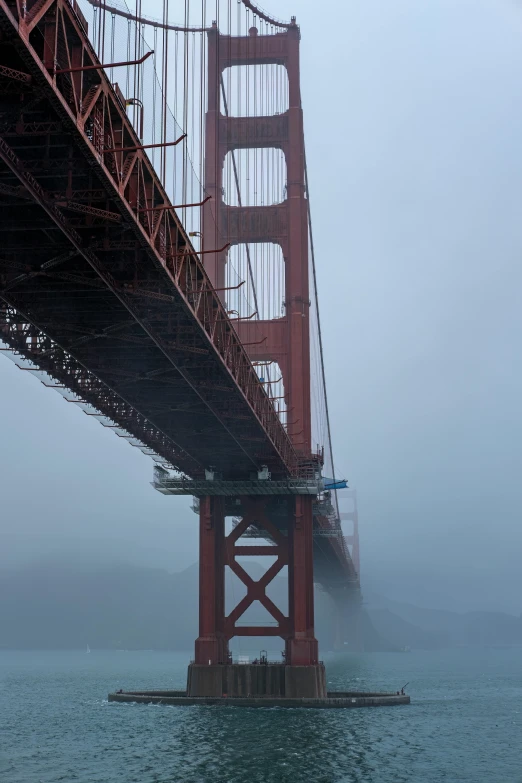 the view from under the bridge of the ocean and a boat below