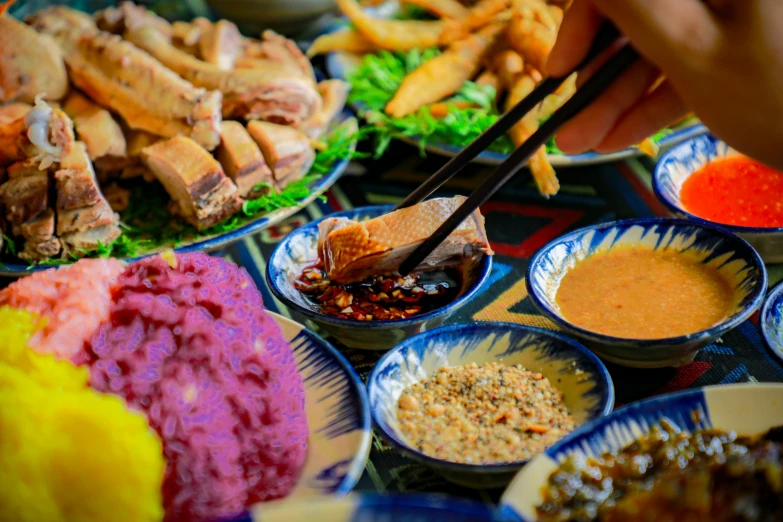 people are gathered around a buffet with asian food items