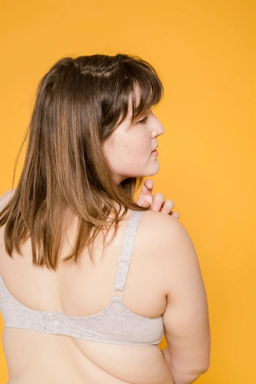 a woman in an undershirt holding a knife in her mouth