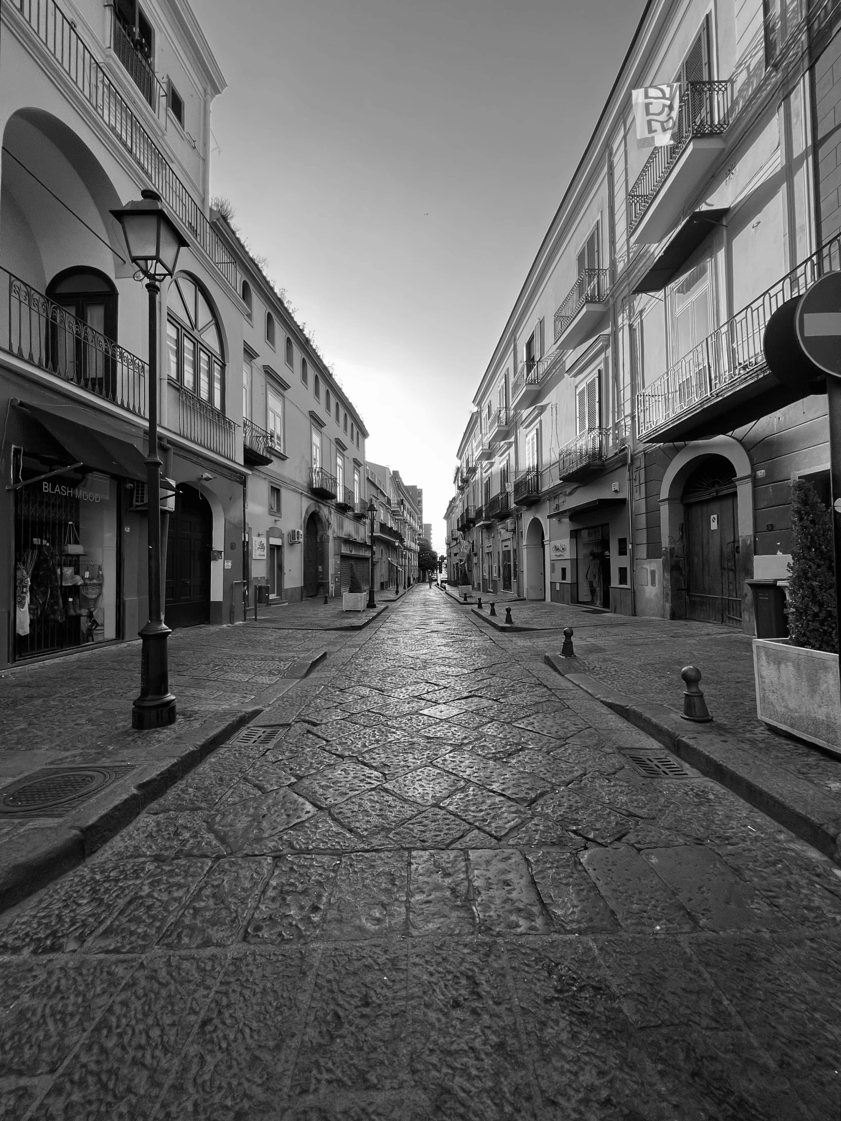 a long empty road with some buildings in the background