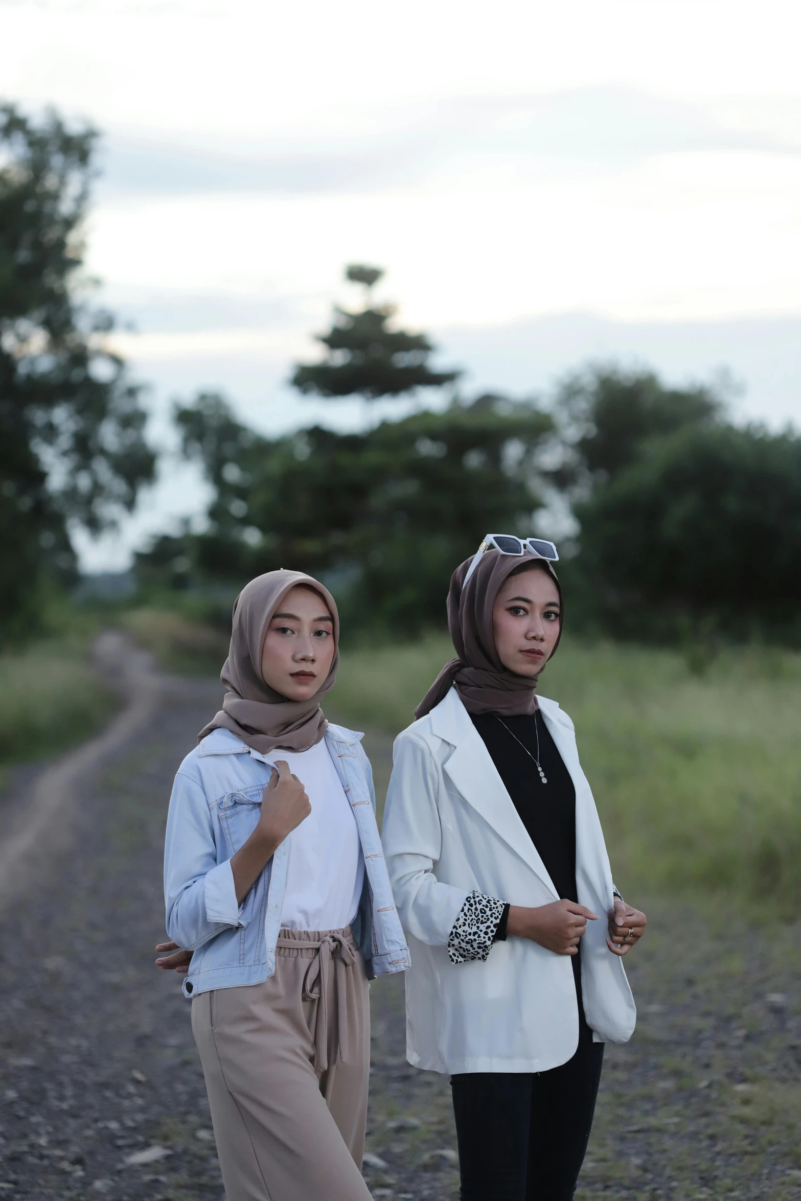 two young ladies standing on the side of a road