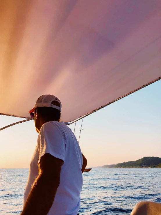 a man standing on top of a boat on a body of water