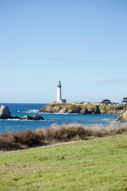 a lighthouse on a green island overlooking the water