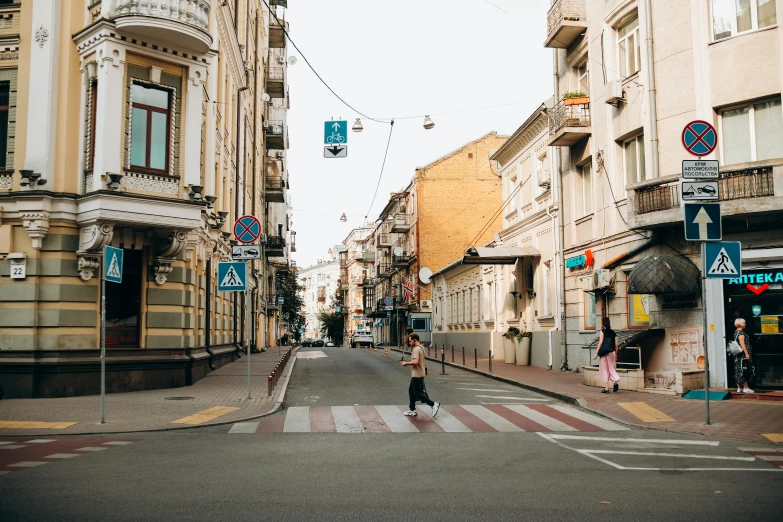 a person crosses an empty street between two buildings