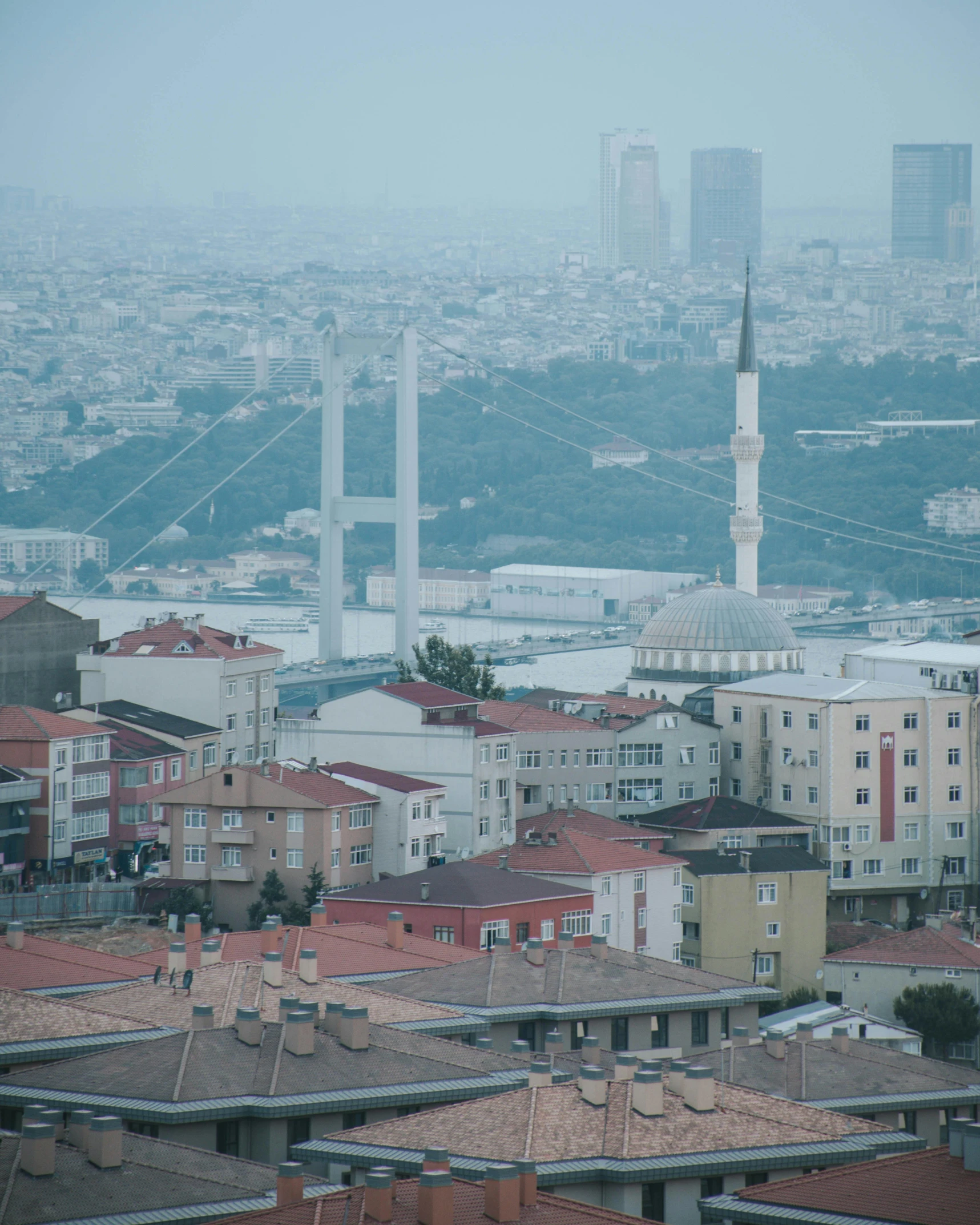 a foggy sky in the middle of city with a skyline full of buildings and a white clock tower