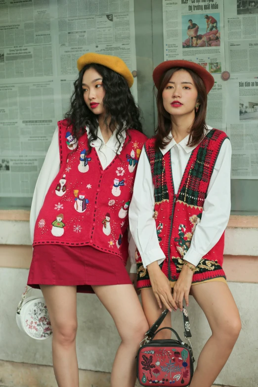 two women dressed up in short dresses and a red purse