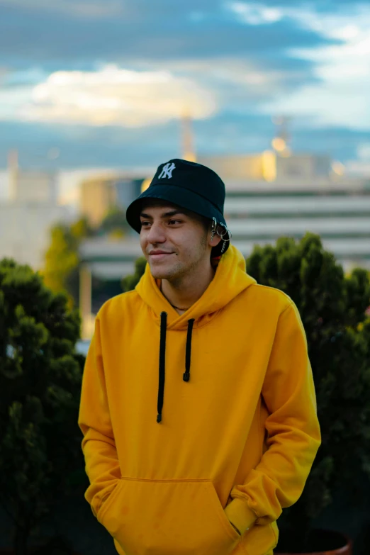 a man in a yellow sweatshirt and a cap