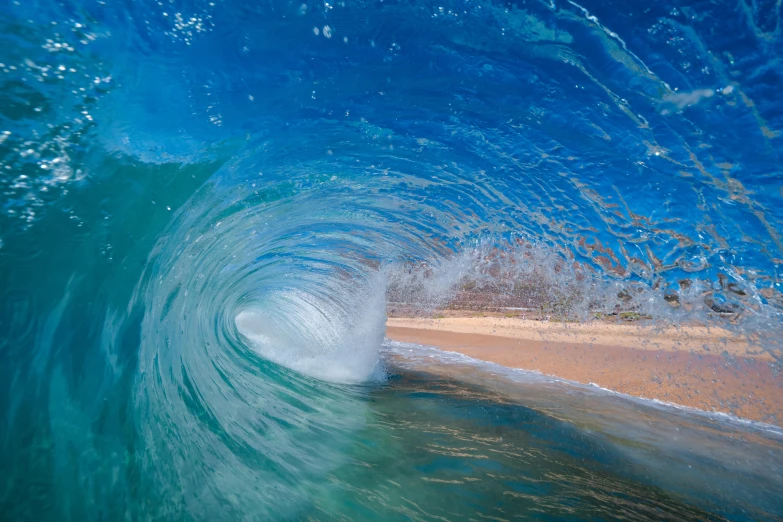 a wave crashes in front of a beach with sand