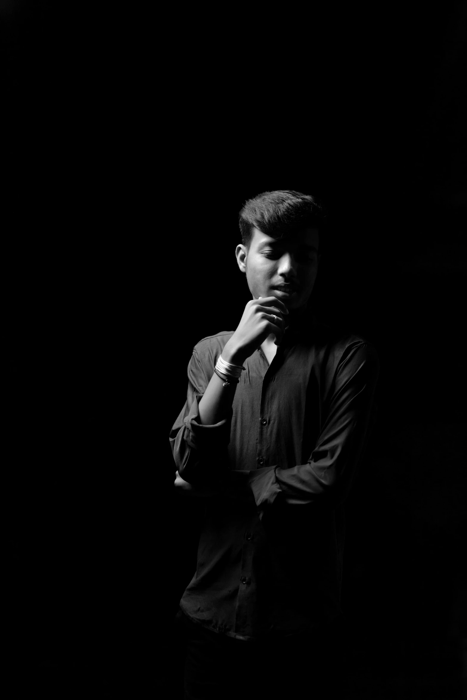 a man in a dark shirt and tie posing for the camera