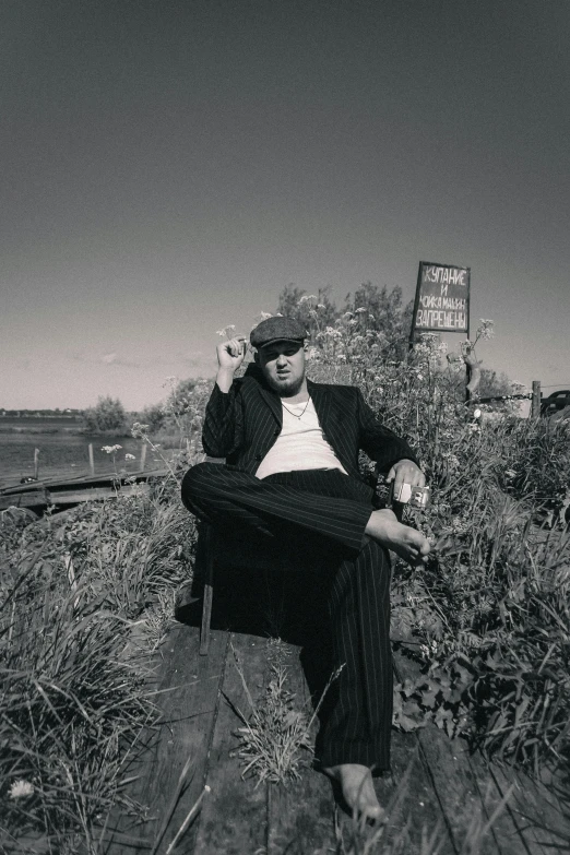 a man sitting on the ground talking on a cell phone